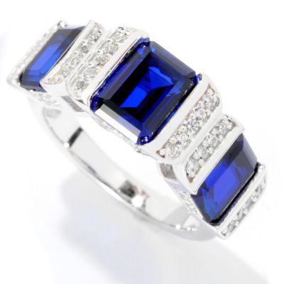 BLTA SS/PLAT EMERALD CUT TENSION SET AND ROUND CUT THREE STONE RING